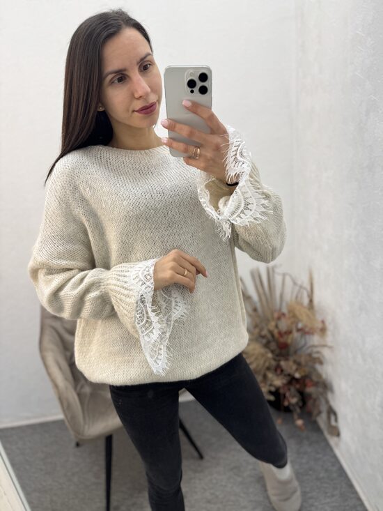 Džemperis ar mežģīni rokas daļā.