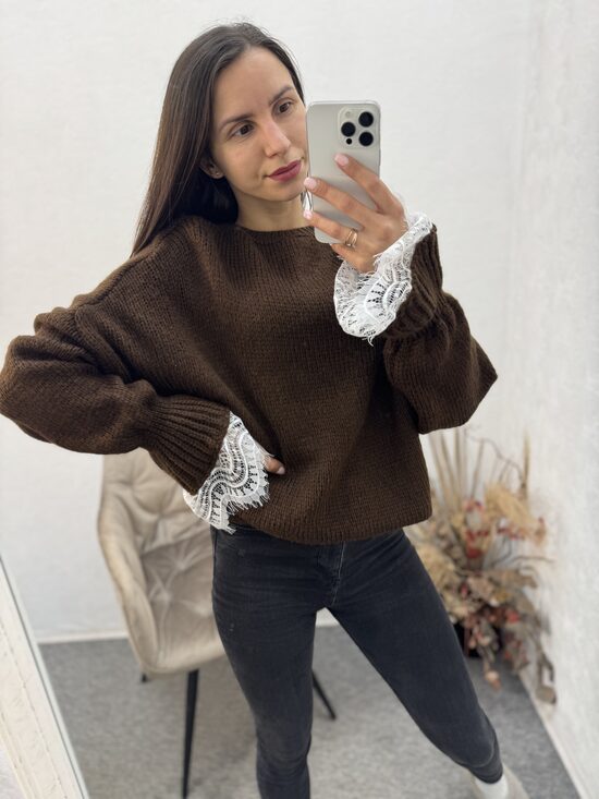 Džemperis ar mežģīni rokas daļā.