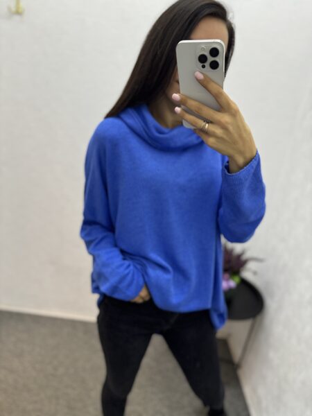 Brīvs džemperis ar paaugstinātu apkakli.